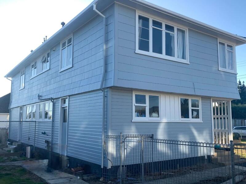 Professional exterior painting of a two-story house, enhancing its curb appeal and protecting its structure