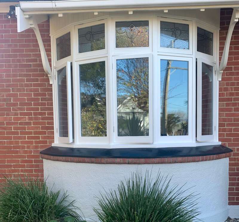 White painting applied to a curved window, enhancing its aesthetic and protective qualities